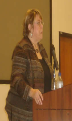 A woman speaking out from a podium.